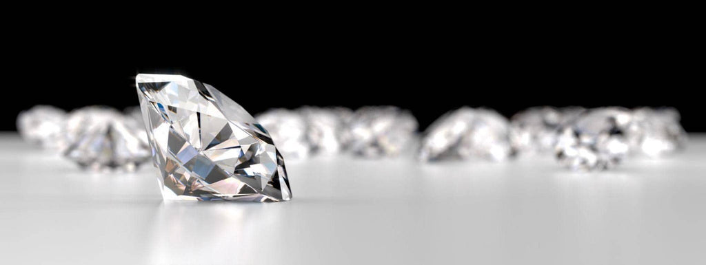 Photo of a diamond in the foreground with additional diamonds, out of focus, in the background